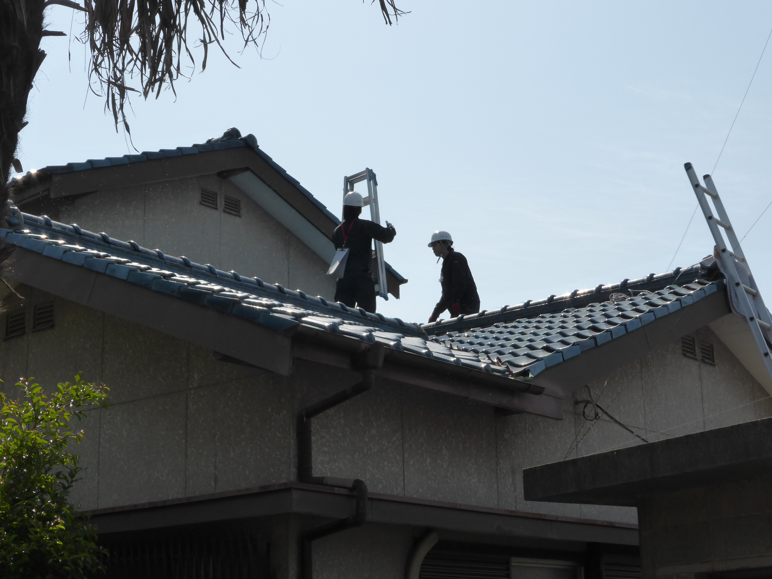 丹念に屋根を検査する２名の住宅検査協会員